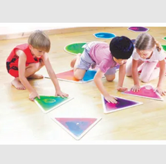 The image depicts three children engaged in play on the floor with sensory liquid floor tiles, which come in various shapes.