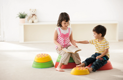 Children using WePlay Rainbow River Stones for seated play and movement activities in an early learning environment