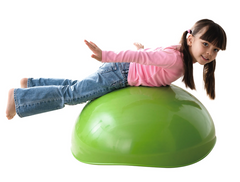 Child balancing on overturned WePlay Rocking Bowl for stretching, coordination and movement play