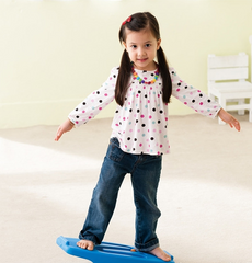 Child standing on WePlay Seesaw Balance & Ball Run while developing balance and coordination