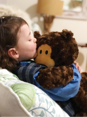 Young child cuddling the Bondi Bear Weighted Companion 1.8kg 