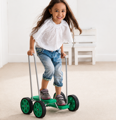 Child enjoying a Weplay Pedal Walker in a bright indoor play space.