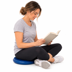 An image of an adult sitting on a blue wriggle cushion while reading.