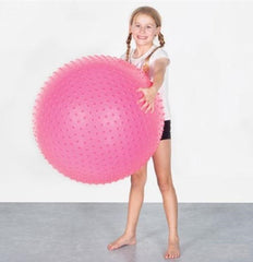 Child engaging with a pink Spike Swiss Ball during an active movement and sensory activity.