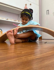 hild using a Wooden Rocking Balance Board for imaginative play and balance