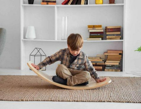 Child using a Wooden Rocking Balance Board for balance, movement and coordination activities