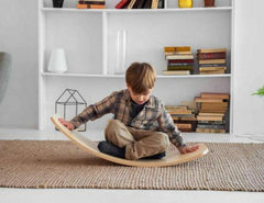 hild using a Wooden Rocking Balance Board for imaginative play and balance