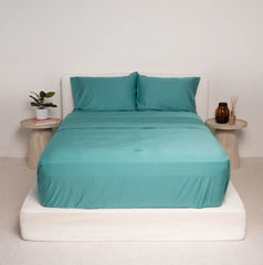 This is an image of a bed made with The Lad Collective™ Original Bedding Set and Fitted Sheets - Easy to Make Bed Linen. This colour is green blue.
