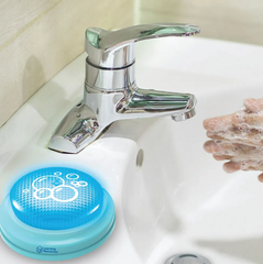 Image of a blue button handwashing timer placed next to a tap where hands are being washed.