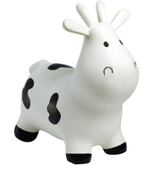 White toy cow with black spots on a white background