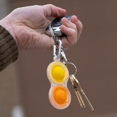 Simpl Dimpl Pop It Key Chain held in hand showing its compact portable size