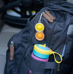 Simpl Dimpl Pop It Key Chain attached to a backpack for portable sensory support