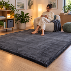 An adult relaxing in a calming space, barefoot on a dark grey memory foam mat.