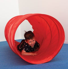 This is an image of a red nylon tunnel. There is a small boy crawling inside.
