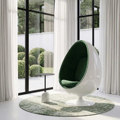 Image of a fiberglass swivel floor egg chair, featuring a white fiberglass exterior and forest green inner cushion.