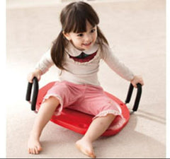 This is an image of a child using the Hand Held Rotation Board. It is red with black handles on the side.