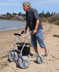 image of a all terrain rollator walker with beach wheels used by a man on the beach