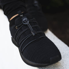 This is an image of black no-tie shoelaces laced onto black shoes. Lock Laces.