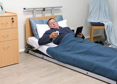 This is an image of a person holding the electronic remote control to adjust the bed into a 70 degree upright position