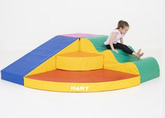 this is an image of a child sliding down some  vinyl covered foam furniture in different colours - sensory spaces