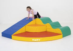 this is an image of a child climbing on some vinyl covered foam furniture in different colours - sensory spaces