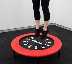 This is an image of a someone's feet jumping on a Mini Trampoline with a red skirt
