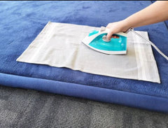 This is an image of a person using an iron and a cover to puff up the Calming Sensory Touch Mats 