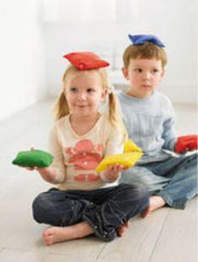 This is an image of kids balancing coloured bean bags on their heads and their hands.