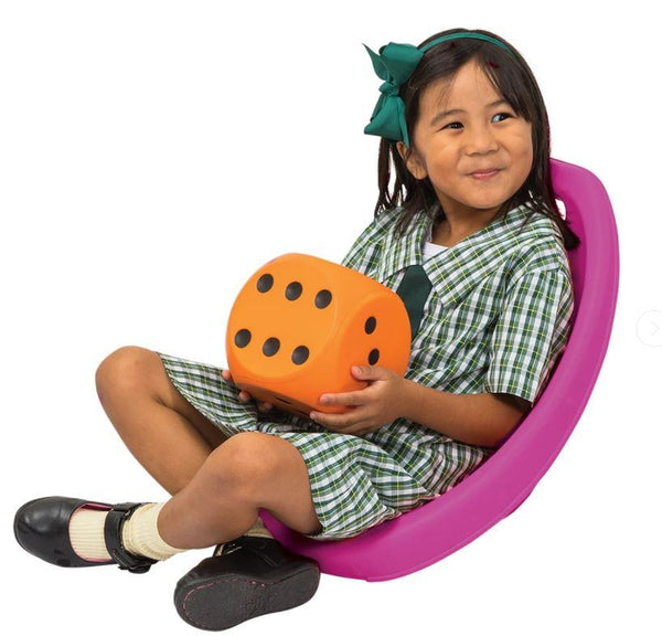 Young child sitting in scoop rocker chair for movement and focus in classroom setting